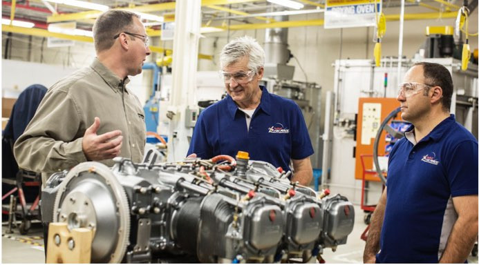 three men looking at the engine